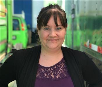 a woman in a purple shirt and black cardigan