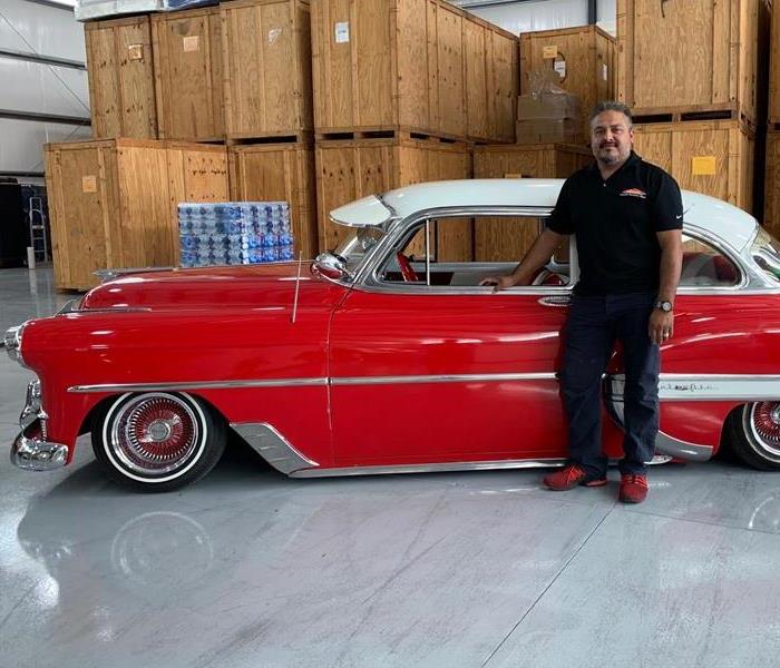 a guy in front of a red car