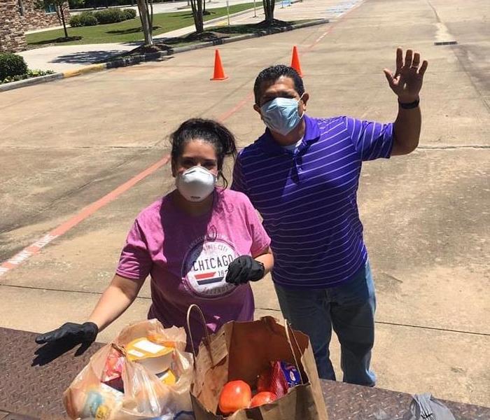 2 people wearing mask unloading a truck